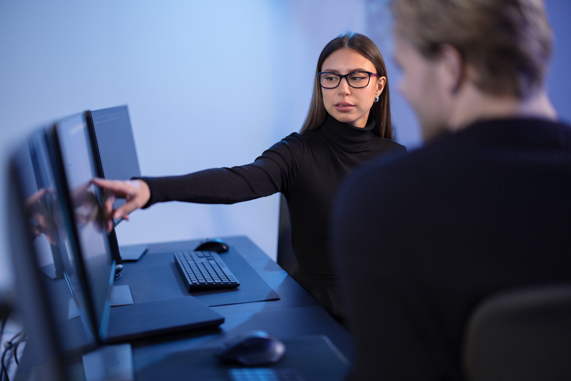 Cybersecurity professionals discussing and analyzing network security data on multiple screens in