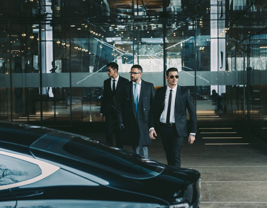 businessman-and-two-bodyguards-walking-to-car.jpg